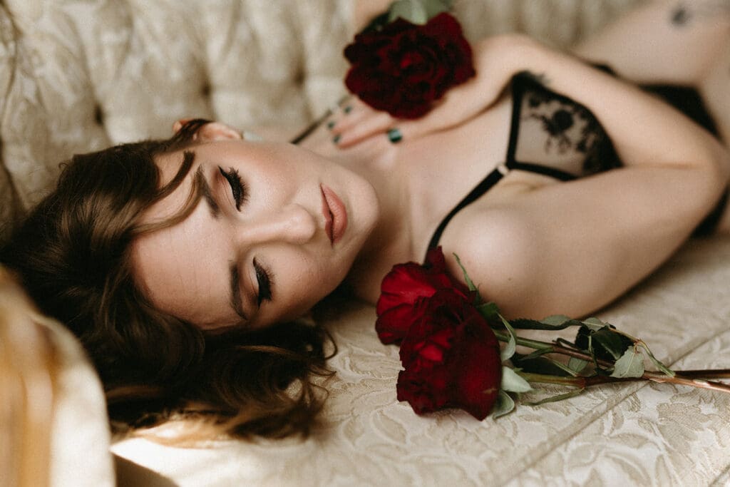 Image of a woman laying on a couch with a rose for her Pre Mastecomy Boudoir Session. 
