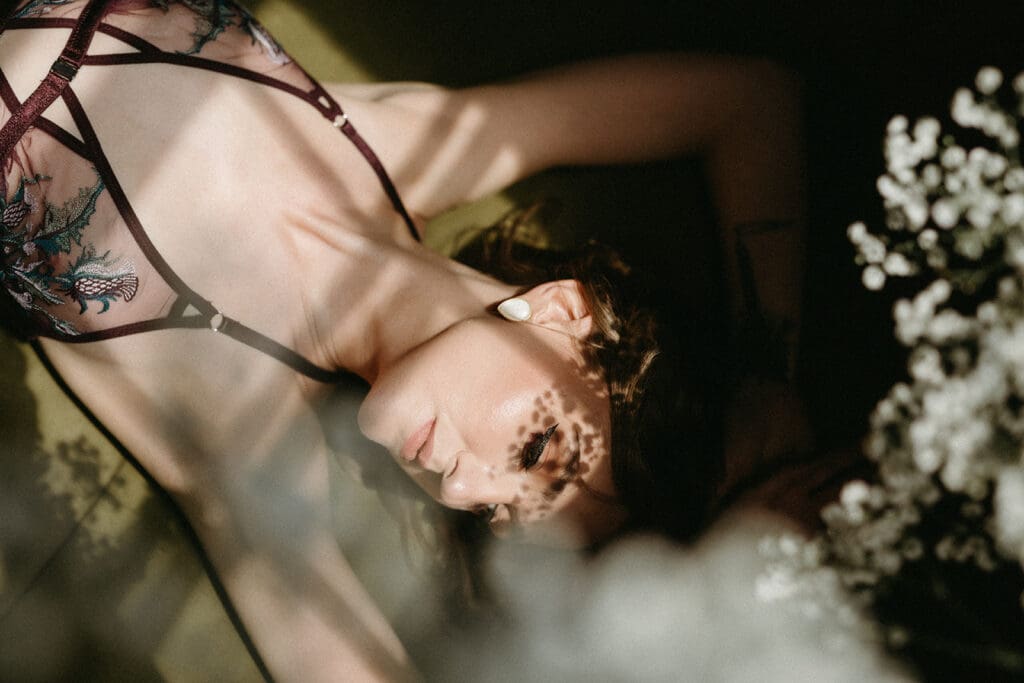 Fine art moody image with direct light and deep shadows for her boudoir session in Richmond, Virginia.