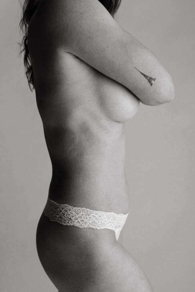 Fine art editorial image of a woman holding her chest in front of a white backdrop.