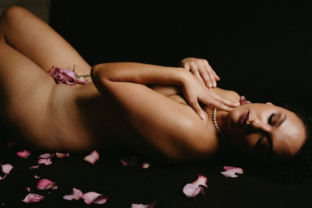 Romantic portrait of a woman covered in rose petals on a Fine Art Backdrop.